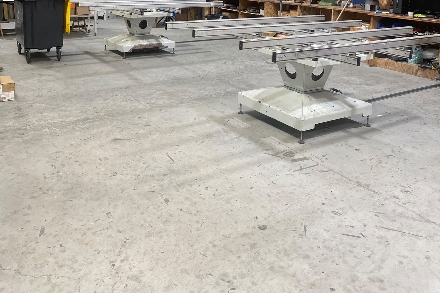 Zone d'assemblage de l'atelier AlexAlu : tables de montage, profilés en attente et établis le long du mur